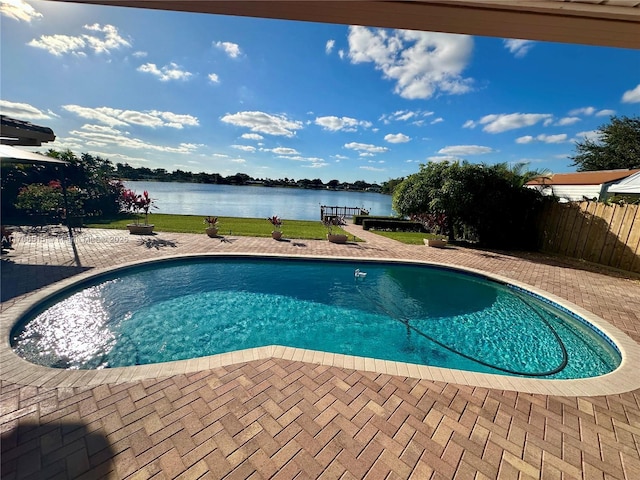 view of swimming pool featuring a water view and a patio