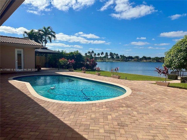 view of swimming pool with a patio area and a water view