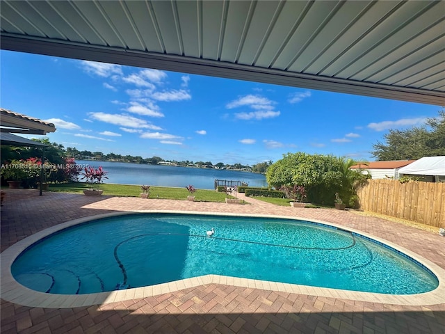 view of pool featuring a water view and a patio