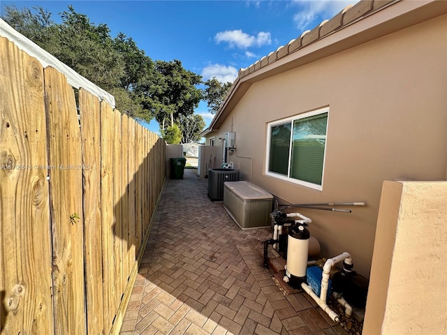 view of side of property with a patio area and central air condition unit