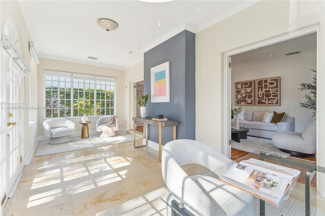 living room featuring baseboards, visible vents, and crown molding