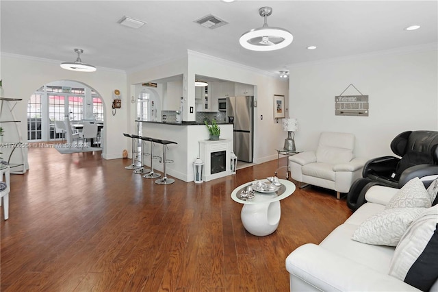 living room featuring ornamental molding and dark wood-type flooring