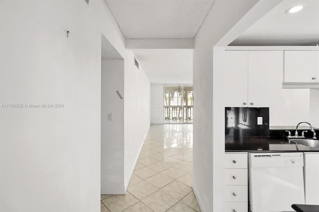 kitchen featuring white cabinetry, sink, white dishwasher, and light tile patterned flooring