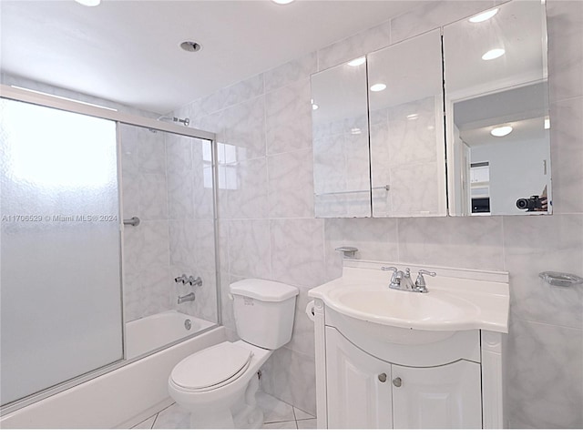 421 NE 14th Ave Unit 203, Hallandale Beach, FL 33009 - bathroom featuring tile walls, vanity, combined bath / shower with glass door, and recessed lighting