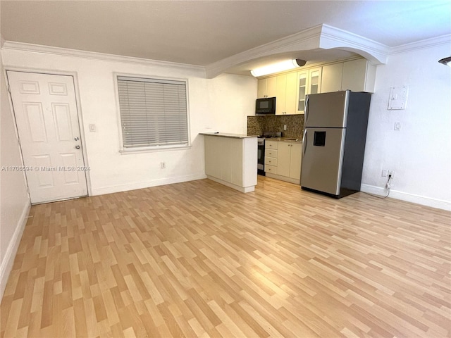 kitchen with crown molding, light hardwood / wood-style flooring, appliances with stainless steel finishes, tasteful backsplash, and white cabinetry