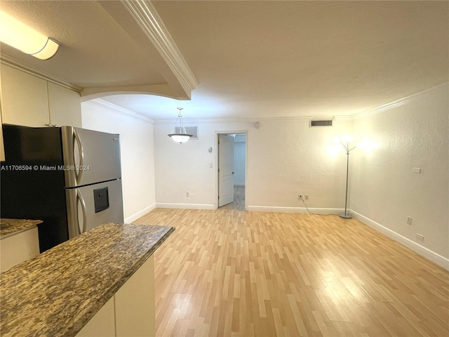 kitchen featuring stainless steel fridge, ornamental molding, decorative light fixtures, and light wood-type flooring