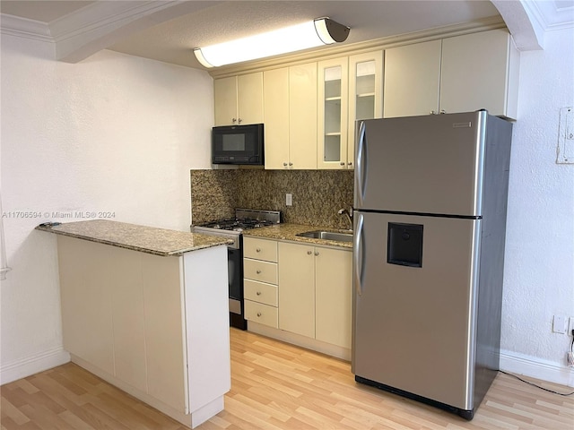 kitchen with light stone counters, light wood-type flooring, and appliances with stainless steel finishes