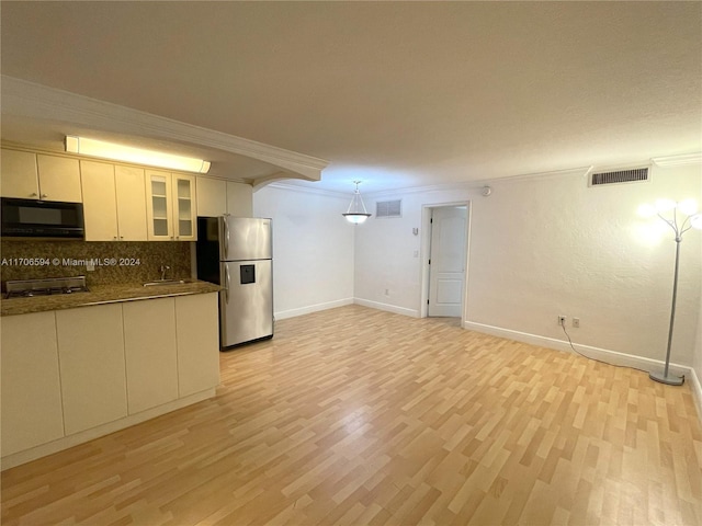 kitchen with pendant lighting, crown molding, stainless steel fridge, light wood-type flooring, and tasteful backsplash