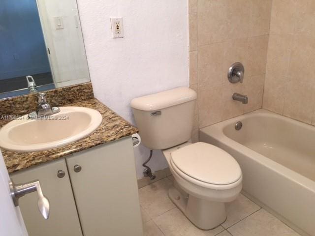 full bathroom featuring tile patterned flooring, vanity, tiled shower / bath combo, and toilet