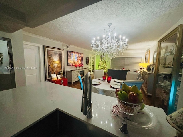 dining room with ornamental molding, a textured ceiling, and a notable chandelier