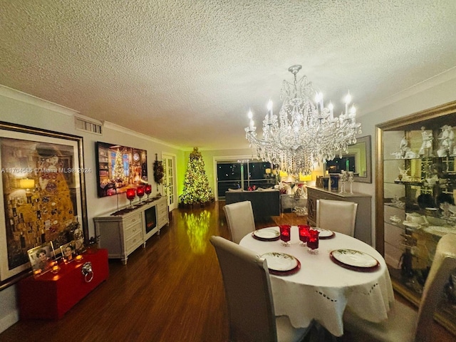 dining space with a textured ceiling, dark hardwood / wood-style floors, and an inviting chandelier