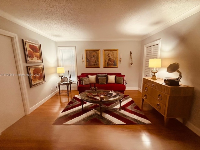 sitting room featuring crown molding, a textured ceiling, and hardwood / wood-style flooring