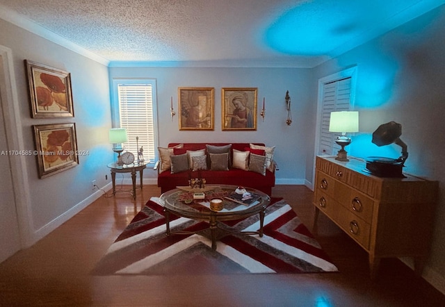 living room with hardwood / wood-style flooring, a textured ceiling, and ornamental molding