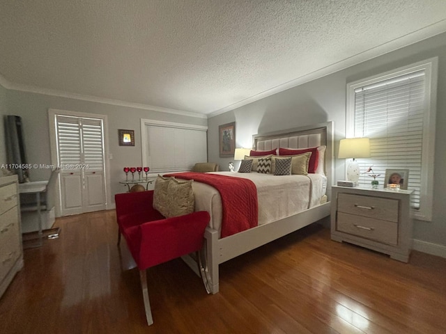 bedroom featuring dark wood-type flooring, a textured ceiling, and ornamental molding