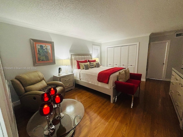 bedroom featuring a textured ceiling, dark wood-type flooring, and a closet