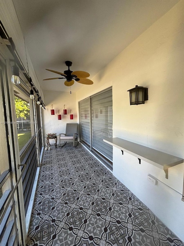 unfurnished sunroom featuring ceiling fan