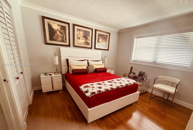 bedroom featuring hardwood / wood-style floors, ornamental molding, a textured ceiling, and a closet