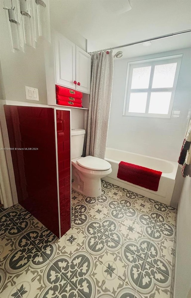 bathroom with tile patterned flooring, toilet, and shower / bath combo with shower curtain