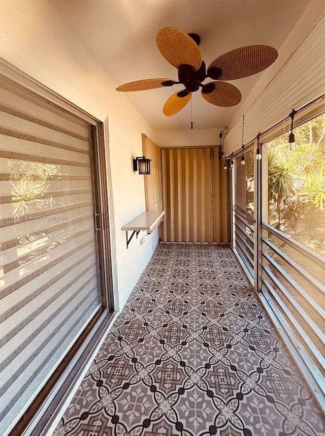 unfurnished sunroom with ceiling fan