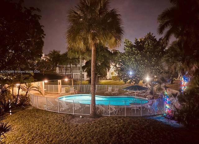 pool at twilight with a patio area