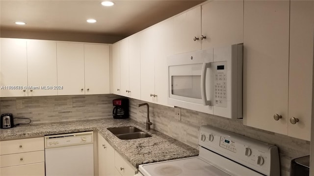 kitchen with sink, light stone counters, backsplash, white appliances, and white cabinets