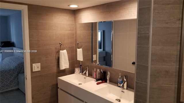 bathroom with backsplash, vanity, and tile walls