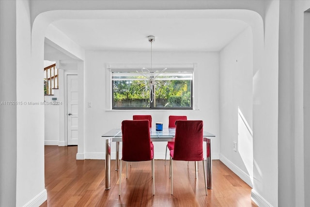 dining room featuring wood-type flooring and an inviting chandelier