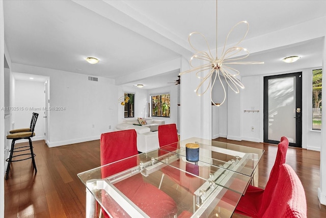 dining area with dark hardwood / wood-style floors and a notable chandelier