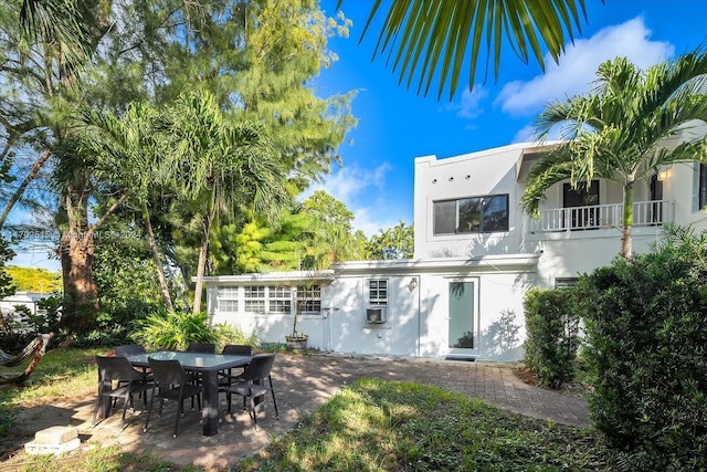 back of property featuring a balcony and a patio