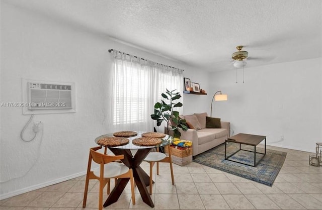 living room with ceiling fan, light tile patterned flooring, a textured ceiling, and a wall unit AC