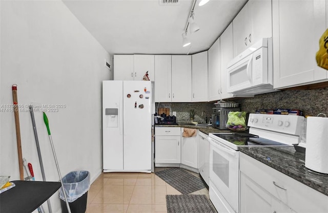 kitchen with white cabinets, backsplash, light tile patterned floors, and white appliances