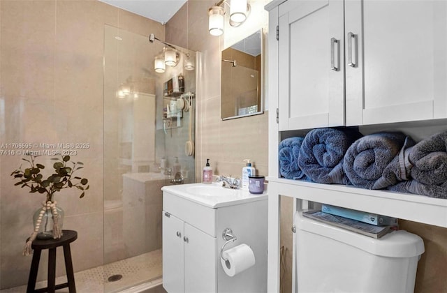 bathroom featuring tiled shower, vanity, and toilet