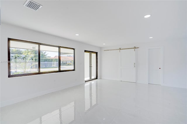 unfurnished room with a barn door