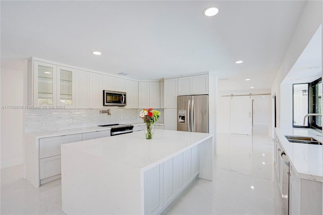 kitchen featuring backsplash, a center island, sink, and appliances with stainless steel finishes