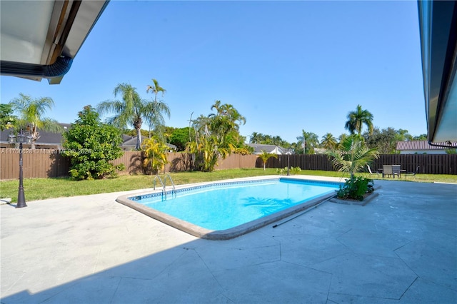 view of swimming pool featuring a yard and a patio