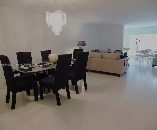 dining space featuring light tile patterned floors and a notable chandelier