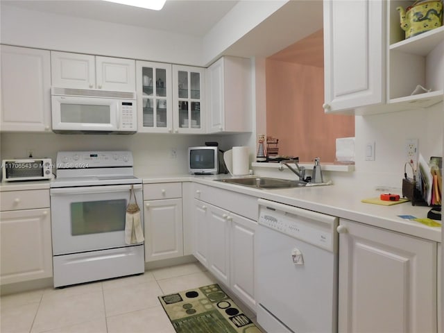 kitchen featuring white cabinets, light tile patterned floors, white appliances, and sink