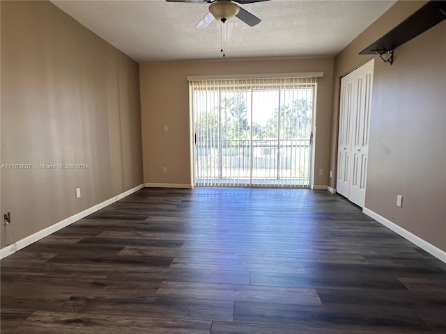 unfurnished room with a textured ceiling, ceiling fan, and dark wood-type flooring