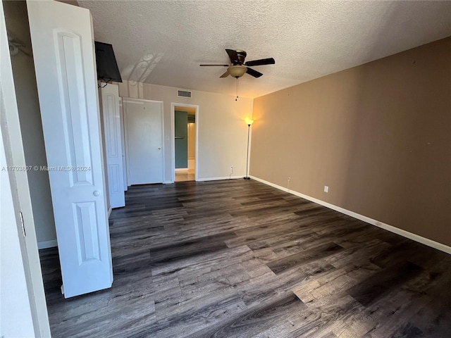 unfurnished room featuring a textured ceiling, ceiling fan, and dark hardwood / wood-style floors