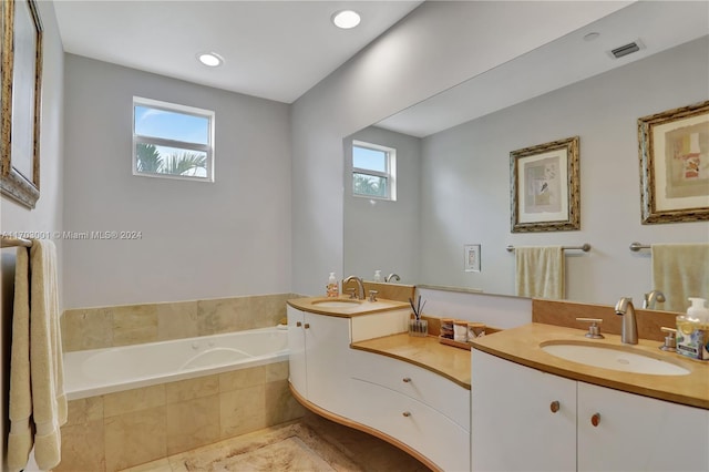 bathroom featuring vanity and tiled tub