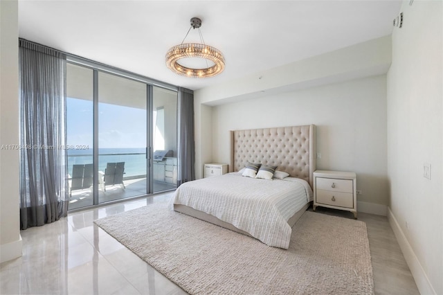 bedroom featuring access to exterior, a water view, and floor to ceiling windows