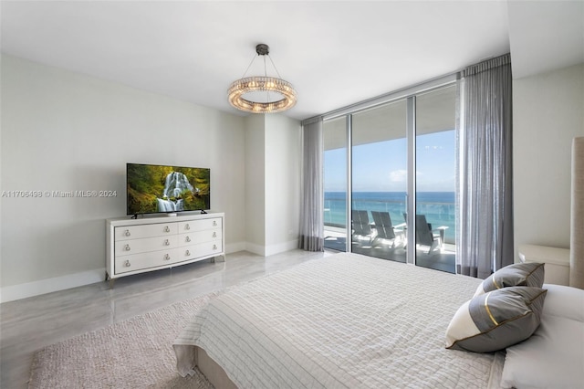 bedroom featuring access to exterior, concrete floors, floor to ceiling windows, and a notable chandelier