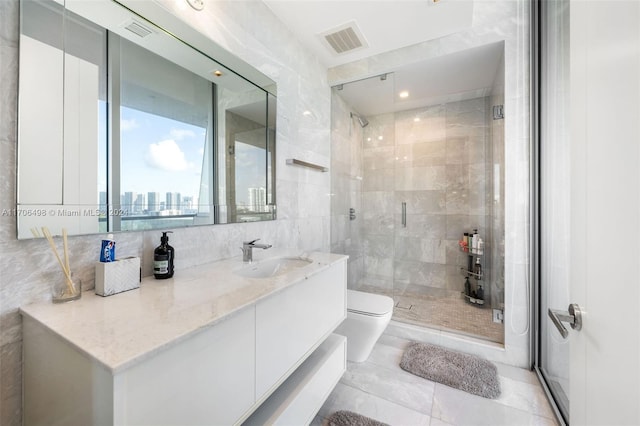 bathroom featuring vanity, a shower with shower door, tile walls, and toilet