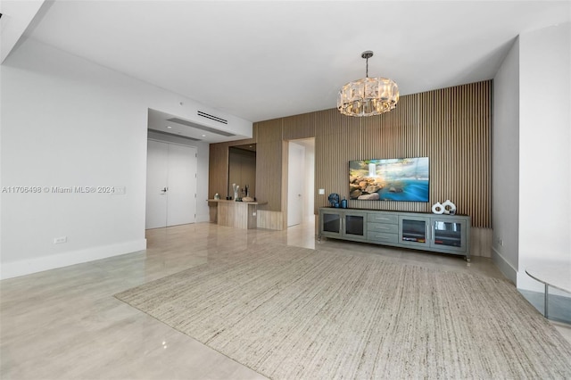 living room featuring an inviting chandelier and wood walls