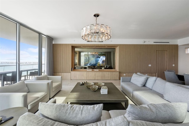 living room with expansive windows, a water view, and a notable chandelier