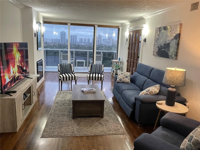 living room with ornamental molding, a textured ceiling, expansive windows, and dark wood-type flooring