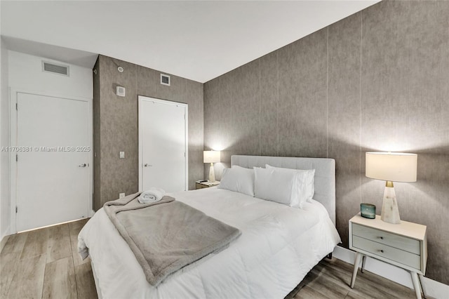 bedroom featuring visible vents and wood finished floors