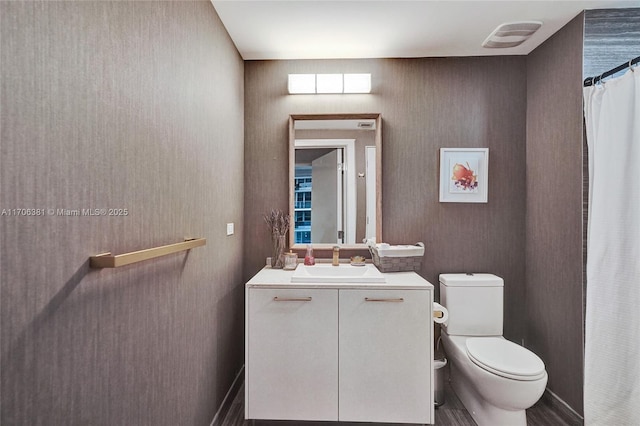 bathroom with wood finished floors, vanity, and toilet