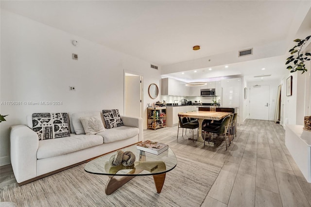 living room with light hardwood / wood-style floors and sink