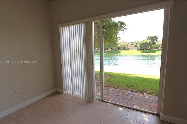 doorway with light tile patterned flooring and a water view